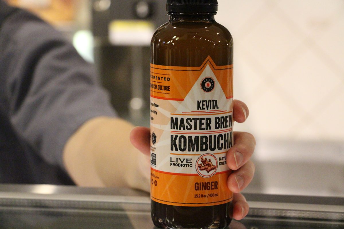 A+Royal+Grounds+employee+shows+off+a+bottle+of+Kombucha.+Royal+Grounds+began+selling+Kombucha+to+cater+to+the+trends+students+are+interested+in.+%7C+Photo+by+Maddie+Christy