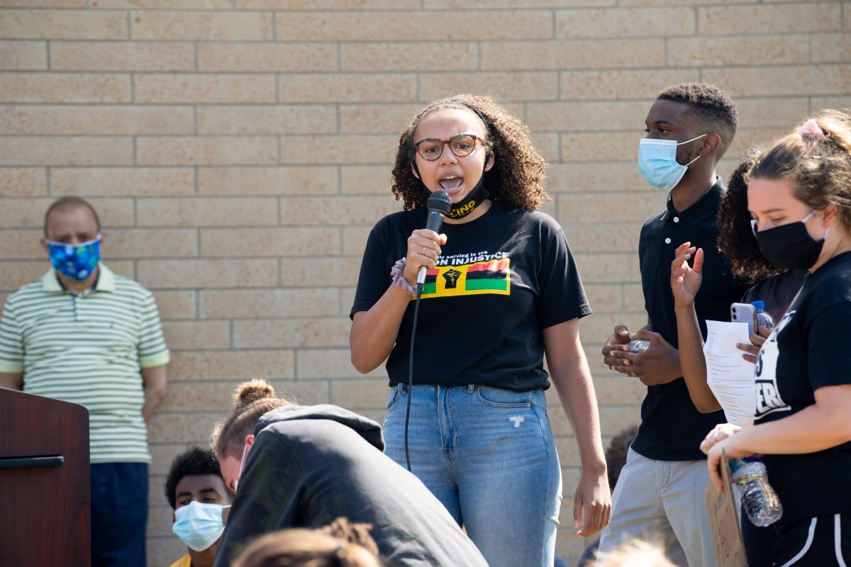 Student leads call and response chant for protesters outside Arden Hills City Hall. Photo by Jake Van Loh.
