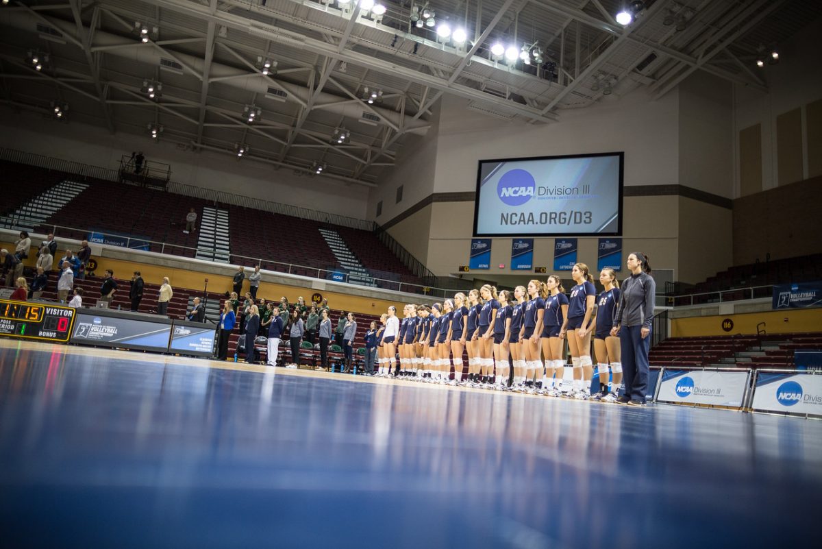 The Bethel University Royals volleyball team stands for the National Anthem before their game.
