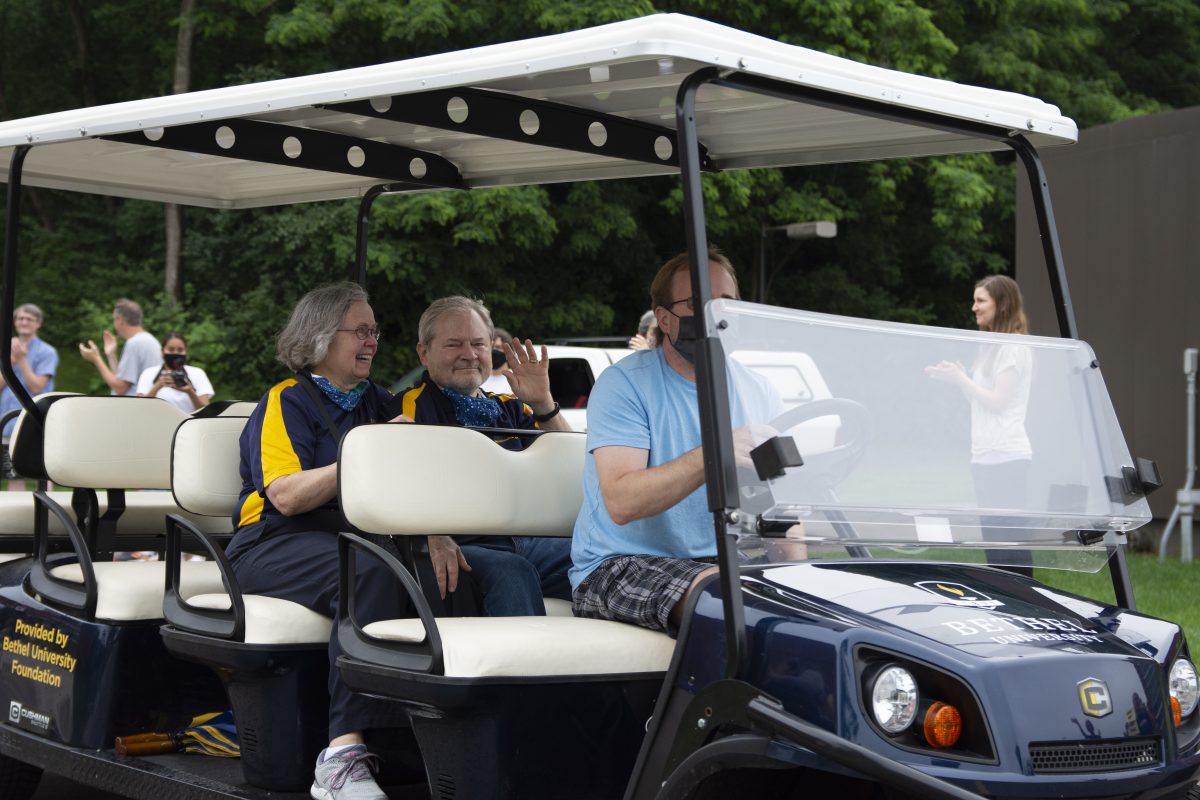Jay and Barb Barnes ride in the back-seat of a golf cart through Bethel on Tuesday, as members of the Bethel community share their support of the former president. | Photo by Emma Gottschalk. 