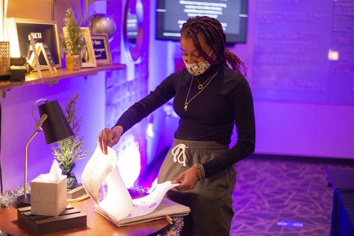 Malakai looks through a sketchbook | Photo by Emma Gottschalk