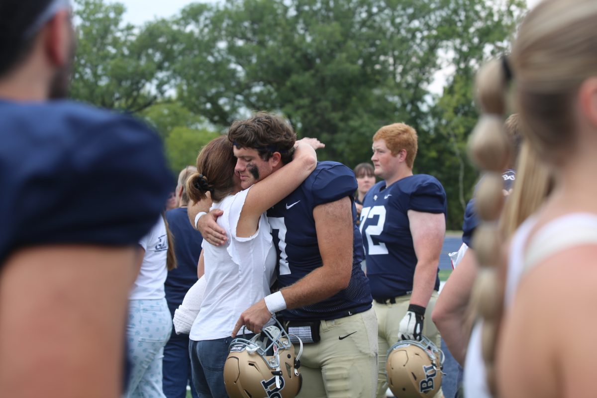 Fifth-year quarterback George Bolt hugs his mom after Bethel University’s first football game of the season Sept. 9. The Wartburg Knights beat the Royals 16-2. “If I’m choosing to come back, I’m choosing to come back fully invested regardless. Even in those frustrating points, I’m going to choose to enjoy this because I can control that,” Bolt said.
