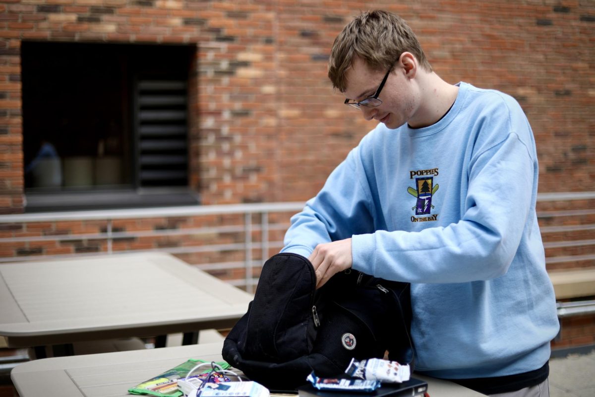 Junior computer science and English student Josh Poppie zips open his Swiss Army backpack that’s been with him all throughout middle school and now stays with him at Bethel.