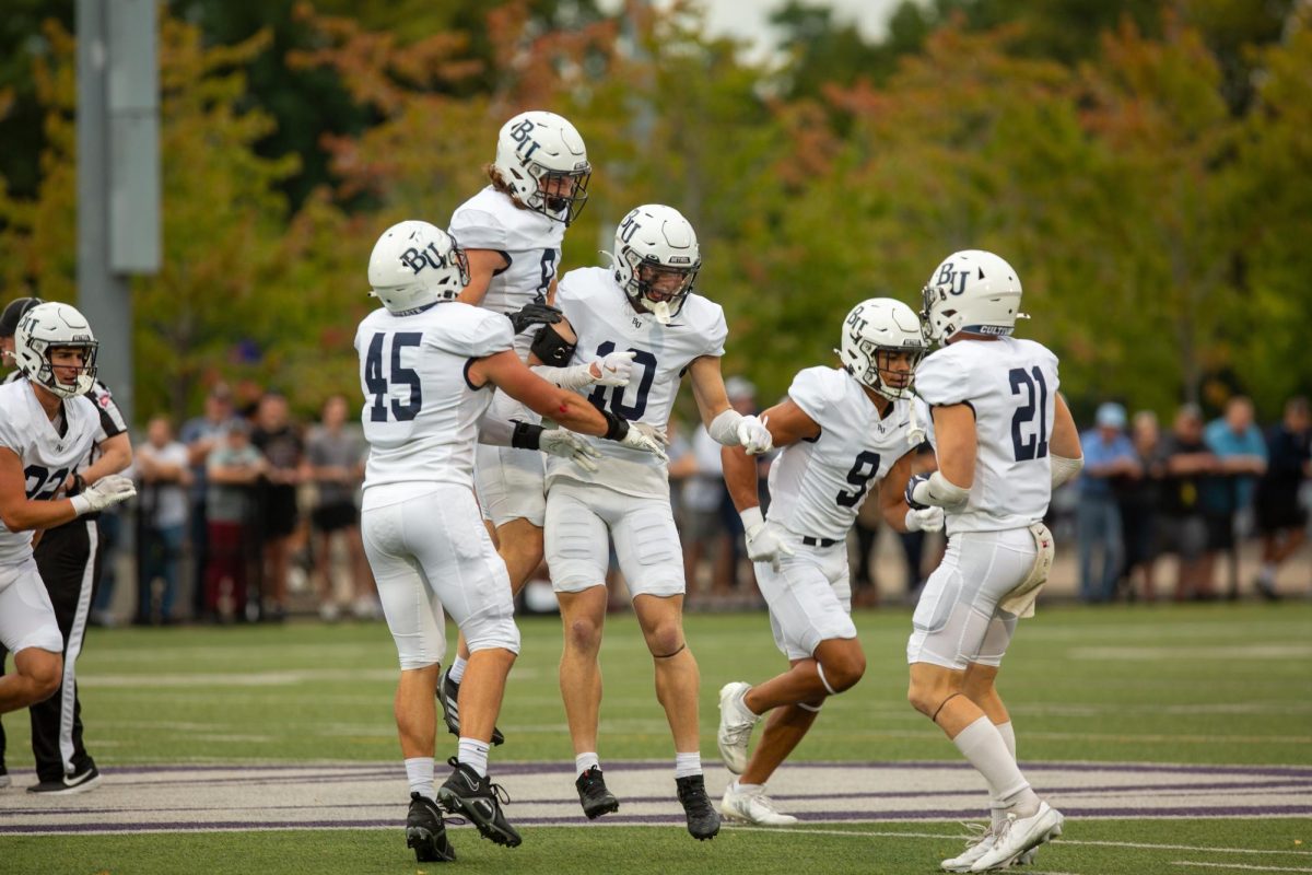 Junior safety Matt Jung celebrates with Bethel’s defense following one of his two interceptions Saturday. Jung led a dominant Bethel defense that held Northwestern’s offense to three points and just 84 total yards. 