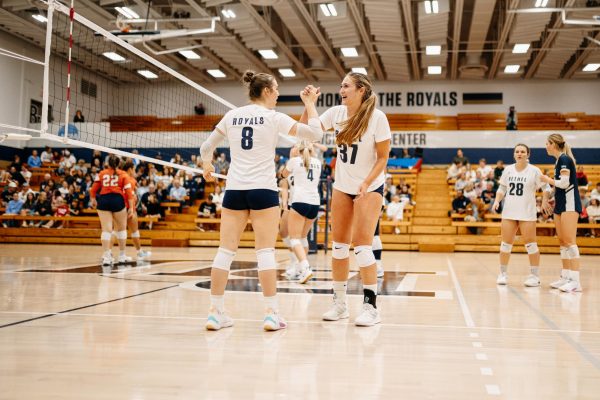 Junior outside hitter Grace Solberg and freshman outside hitter Lauren Hetfeld celebrate after a kill during Wednesday’s game against Macalester College. Solberg’s .512 hitting percentage was key to the Royals 3-0 victory Wednesday night. | Photo by Bennett Moger