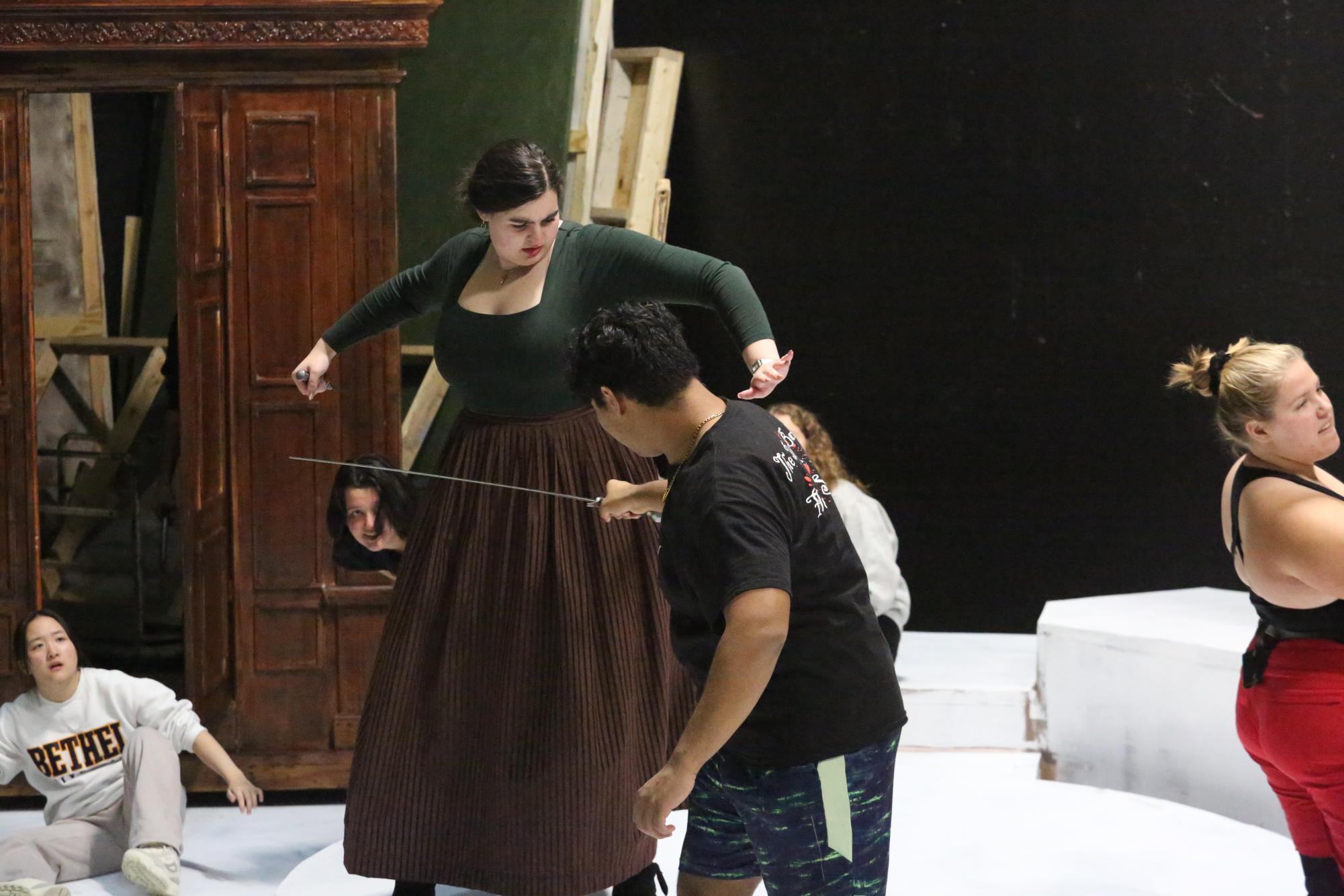 Cadie Logston practices a fight scene as the White Witch with cast member Leo Fay as Peter. The weapons used in the production were brought in by stage combat trainer Aaron Preusse. | Photo by Amy Holmberg