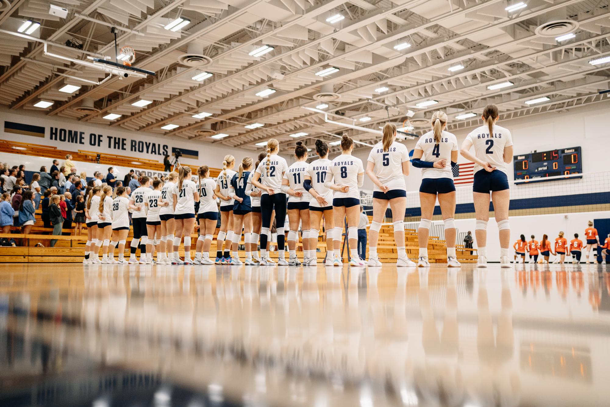 The Bethel University Royals volleyball team stands for the national anthem ahead of their matchup versus Macalester College October 2. | Photo by Bennett Moger