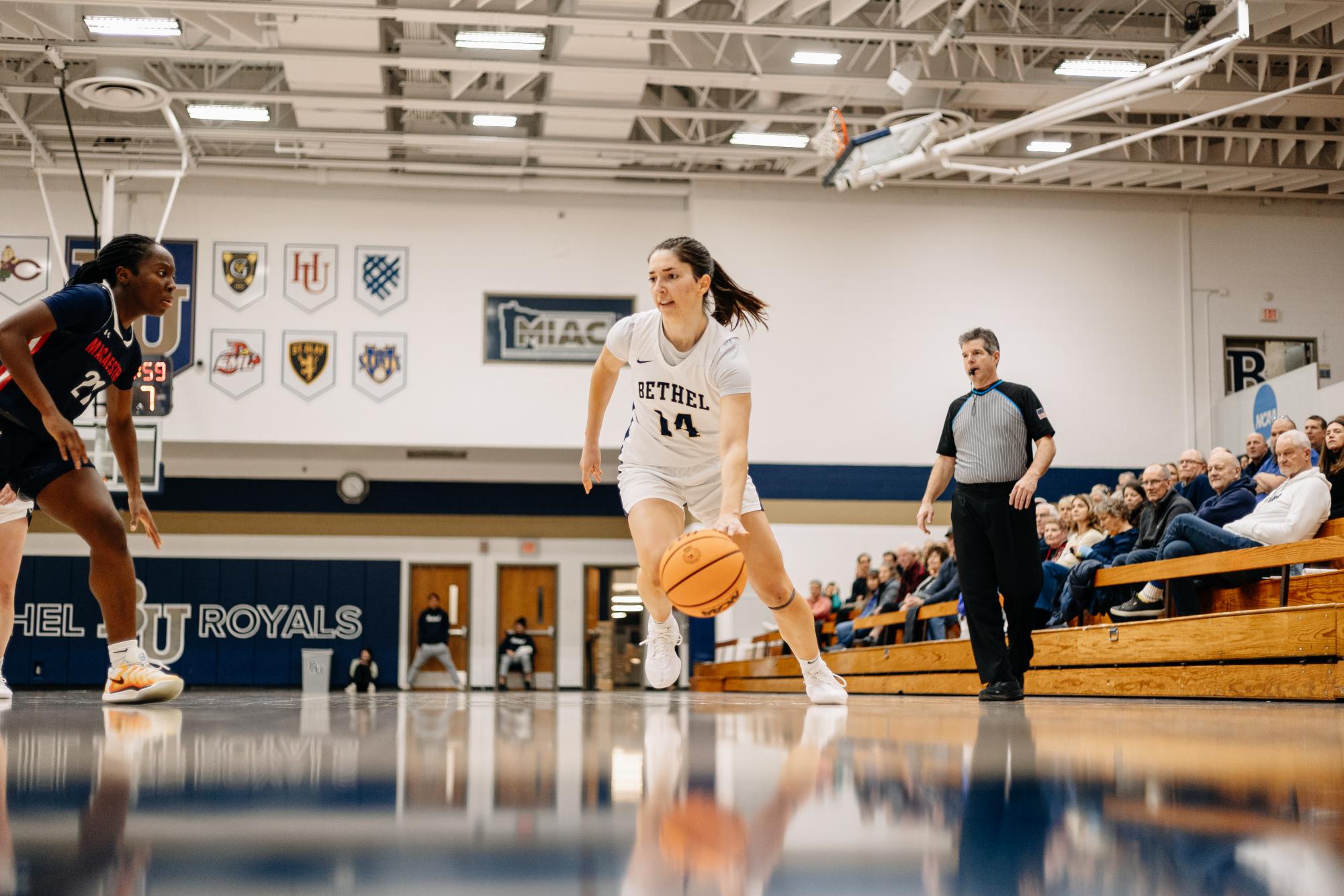 Bethel fifth-year guard Anna Garfield drives past a Macalester defender Jan. 11. Garfield scored her 1,000th point Wednesday night in a 77-47 demolition of Carleton College. 