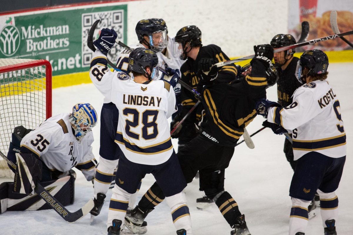 The Bethel University and St. Olaf College men’s hockey teams tussle in front of the net during the Royals 3-1 win over the Oles on Friday Feb. 22 at Bethel University Arena. “We’ve already played St.Olaf three times,” junior center Jack Brown said. “Playing another MIAC team, especially a team that we lost to in the championship, just builds up even more momentum.”