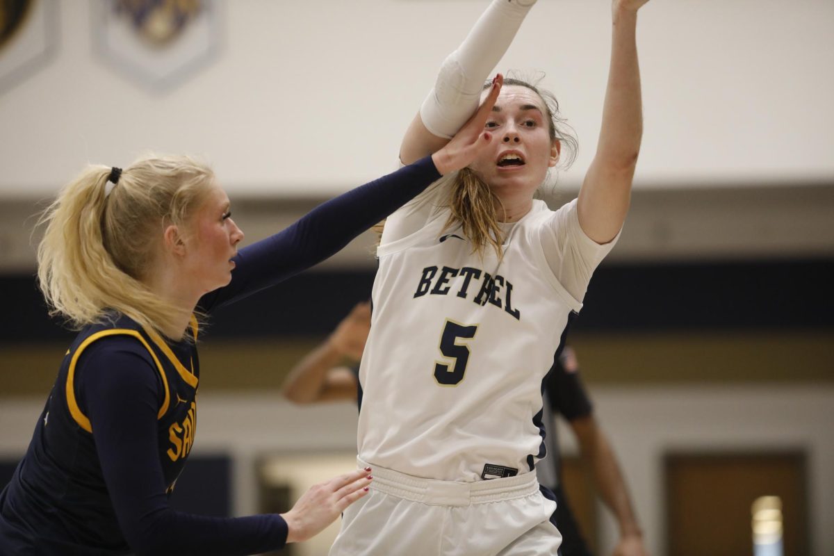 Senior Bethel forward Elly Schmitz throws out a pass amidst tight defense. Schmitz totaled 14 points and 12 rebounds in the Royals' win Saturday. 