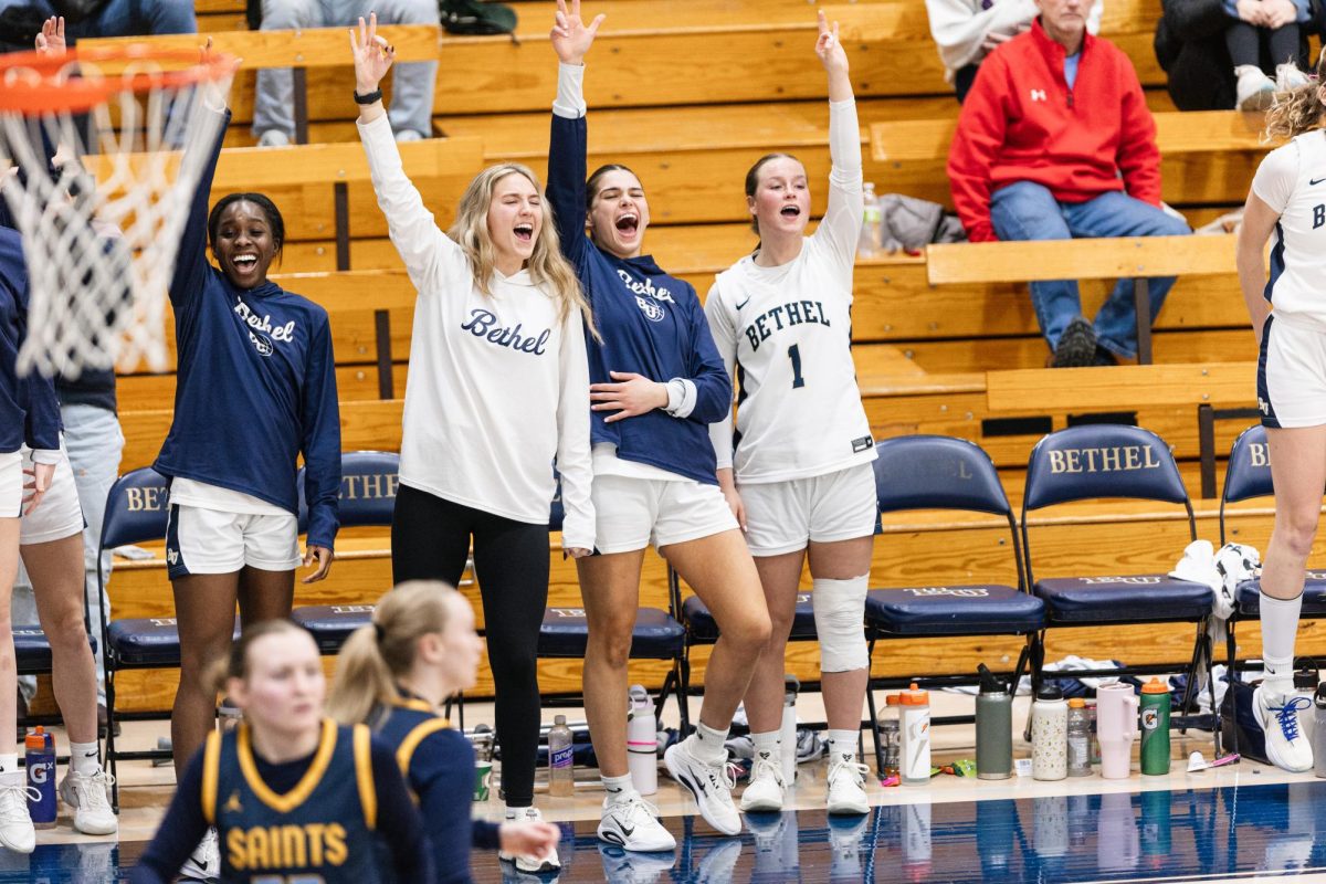 Macey Littlefield, second from left, Lexi Schermann, middle, and Berkley Neubauer, right, celebrate on the bench after Bethel guard Alaina Bonacquista drained a three-pointer late in the game vs. St. Scholastica at the Robertson Center in Arden Hills Feb. 7, 2026. Littlefield, a consistent contributor, has been out with an ankle injury for the past two games. 