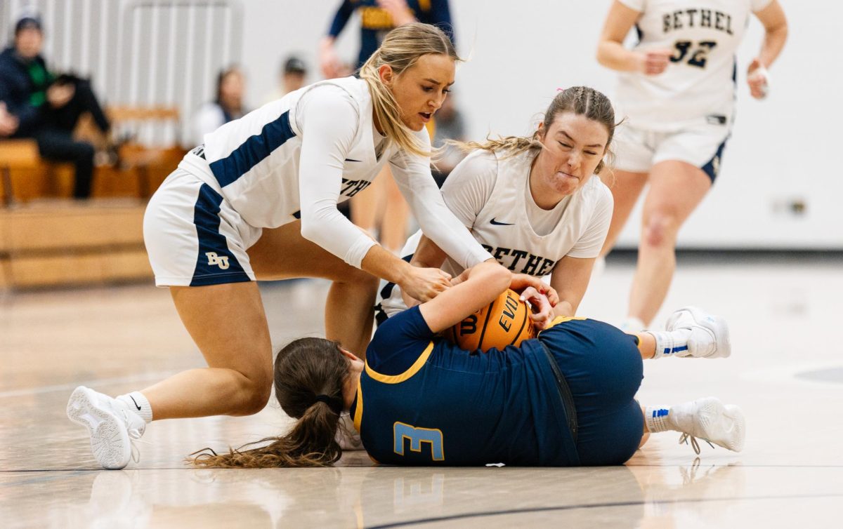 Senior guard Coco Duininck, top left, and senior forward Alli Born, top right, fight for the ball from Saints guard Ava Riegel after Duininck tipped the ball toward the Royals' end at the Robertson Center in Arden Hills Feb. 7, 2026. The physical, back-and-forth game resulted in Bethel sneaking away with a win, 77-71.